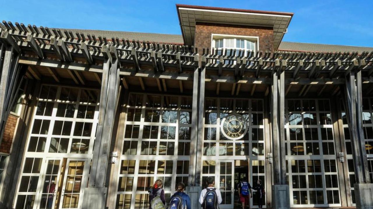 Student walking towards Dutton Hall where Financial Aid is located.