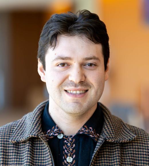 Headshot of Christian Cazares smiling warmly in front of a blurred background. 