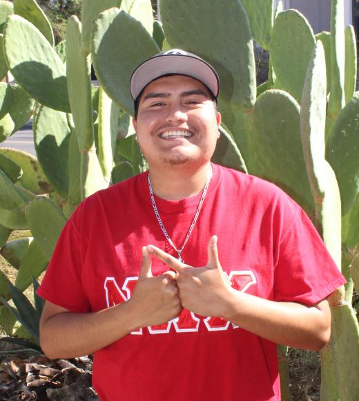 Josue standing in front cacti.