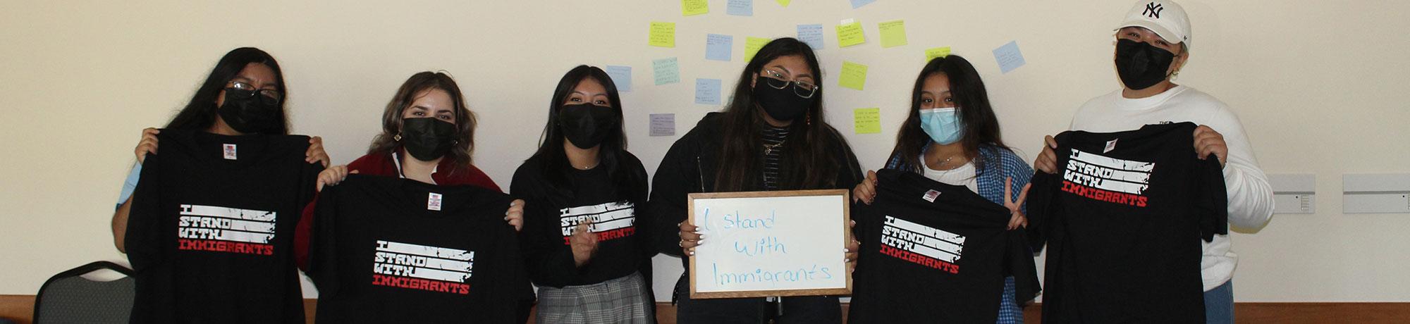 Students holding up shirts